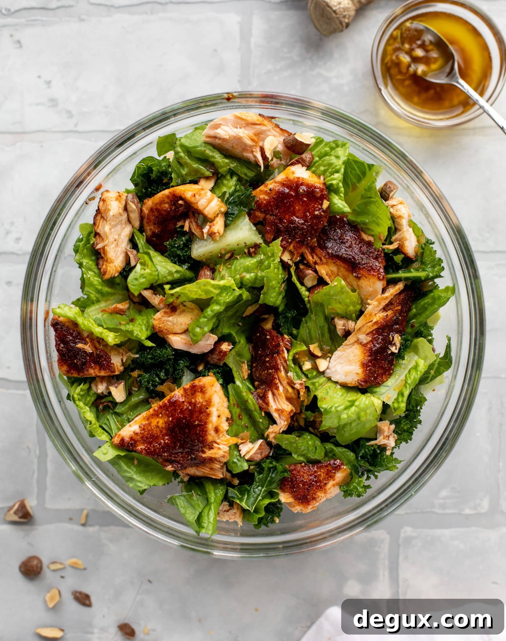 This ginger salmon salad has the flaky, flavorful roasted salmon on top of kale and romaine, drizzled with warm ginger vinaigrette.