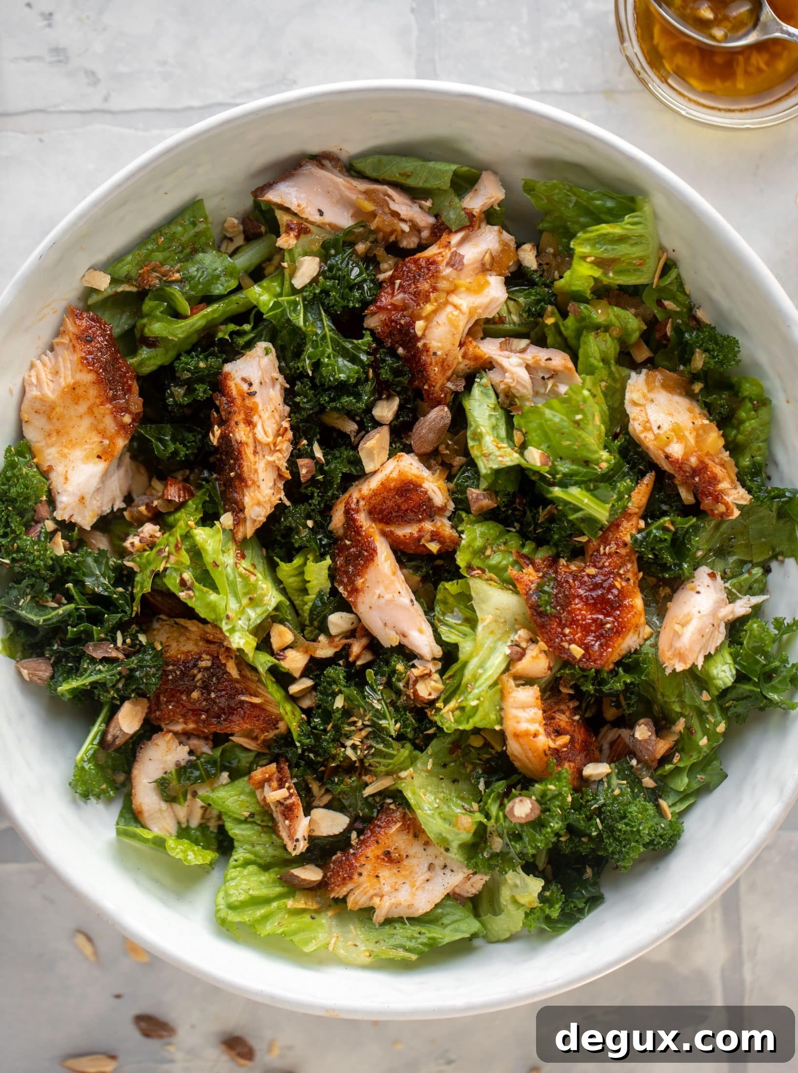 This ginger salmon salad has the flaky, flavorful roasted salmon on top of kale and romaine, drizzled with warm ginger vinaigrette.