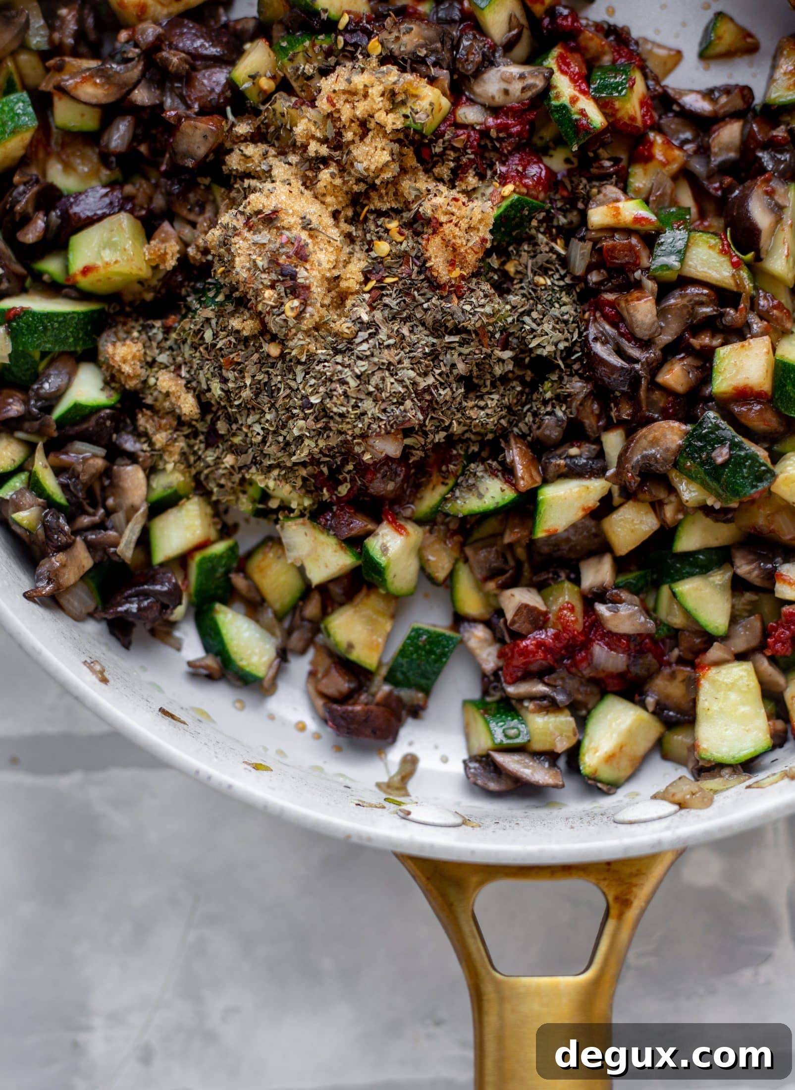 spices with zucchini and mushrooms in a skillet