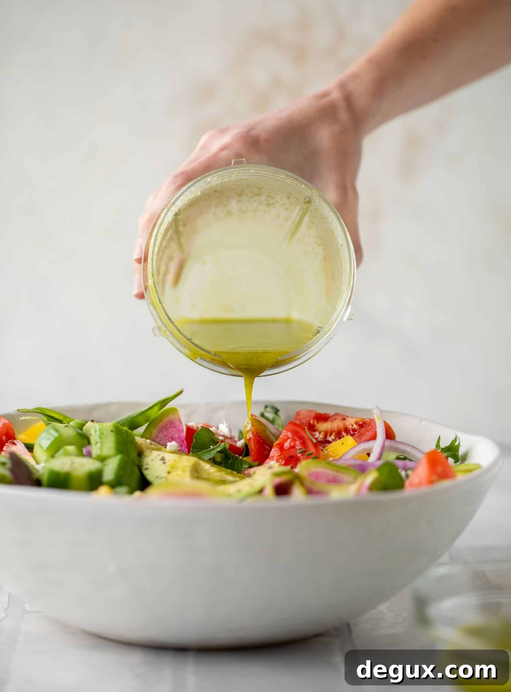 Loaded Summer Salad with Grilled Veggies and Feta 7 pouring vinaigrette on salad