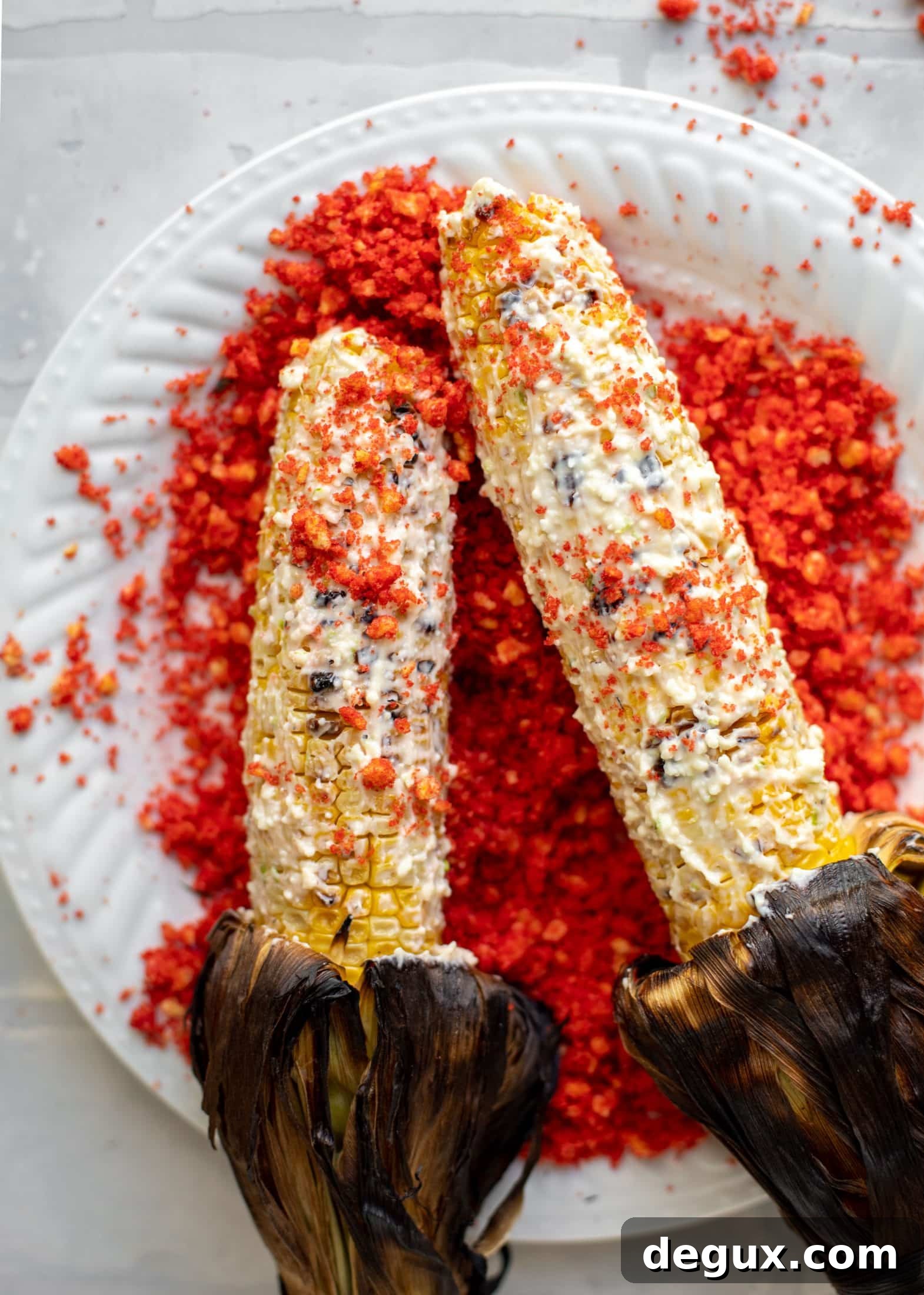 rolling corn on the cob in cotija mayo