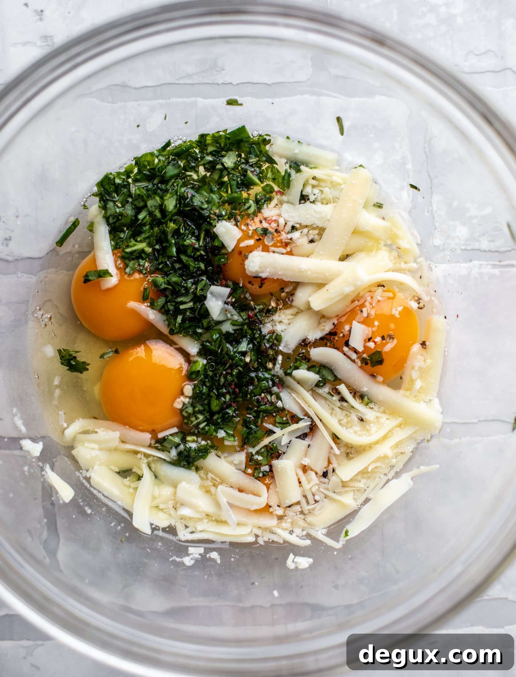 Crispy Potato Chip Frittata with Caramelized Onions 3 eggs, cheese and herbs in a bowl