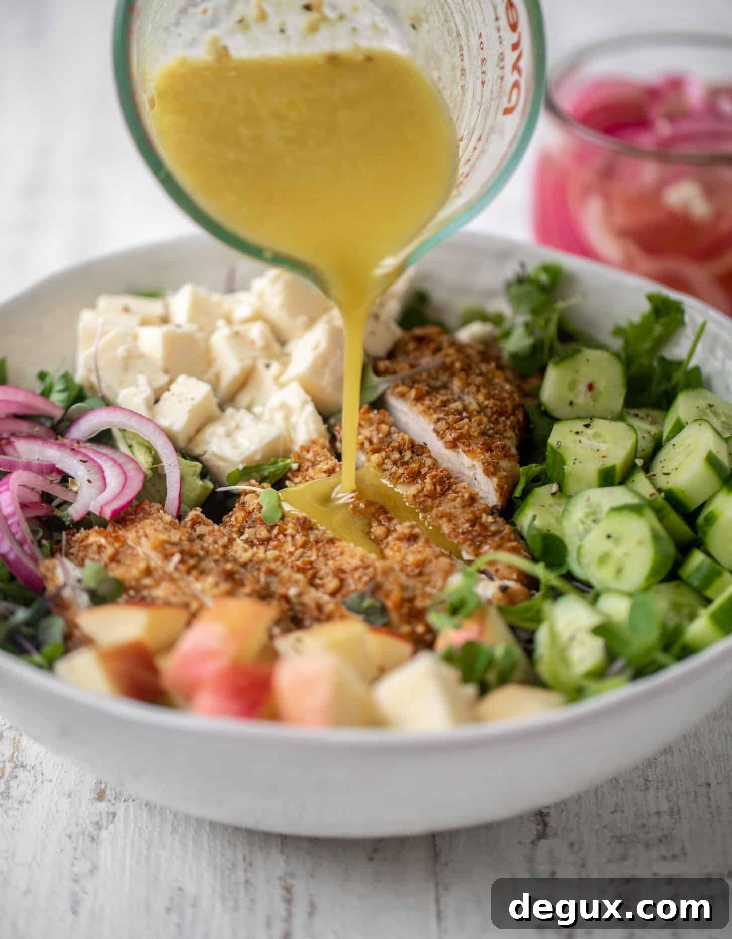 Crunchy Pretzel-Crusted Chicken Salad with Tangy Mustard Vinaigrette 7 pouring dressing on pretzel crusted chicken salad