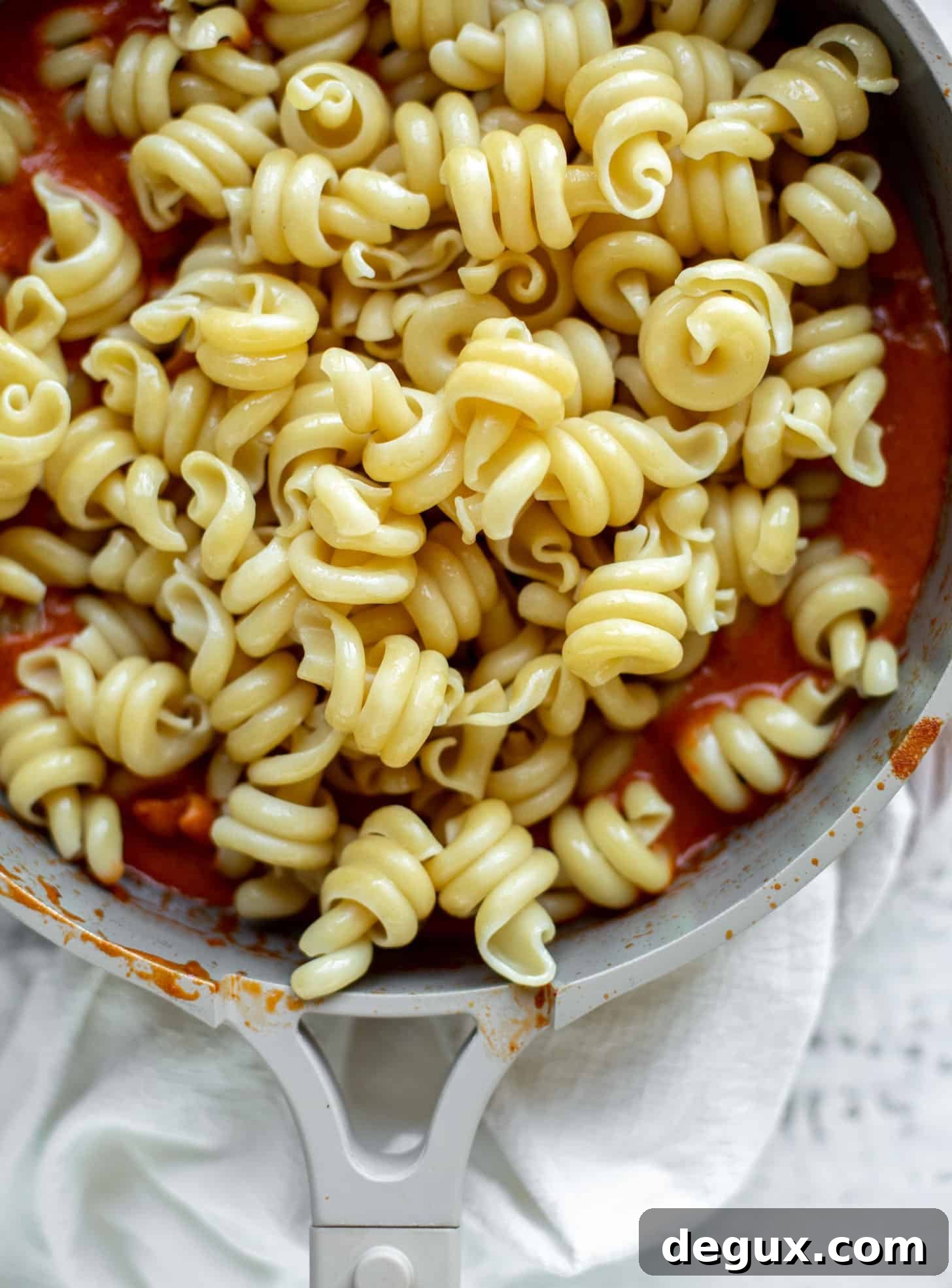 tossing pasta in vodka sauce