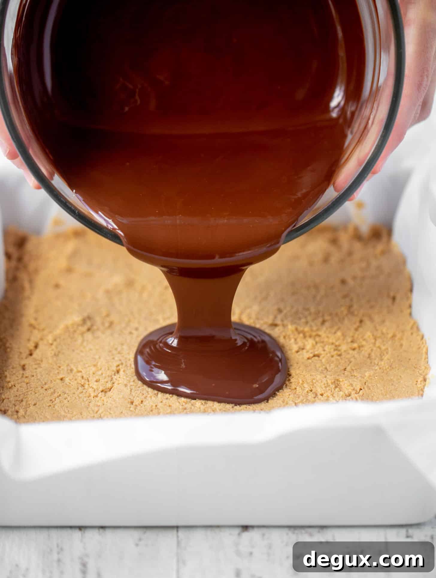 Salted Peanut Butter Cup Bar Recipe — Chewy Chocolate-Peanut Bars 3 pouring chocolate on peanut butter bars