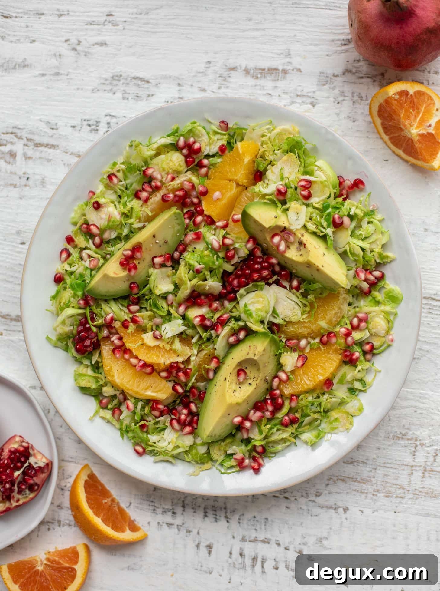 shredded citrus brussels sprouts salad with avocado and pomegranate