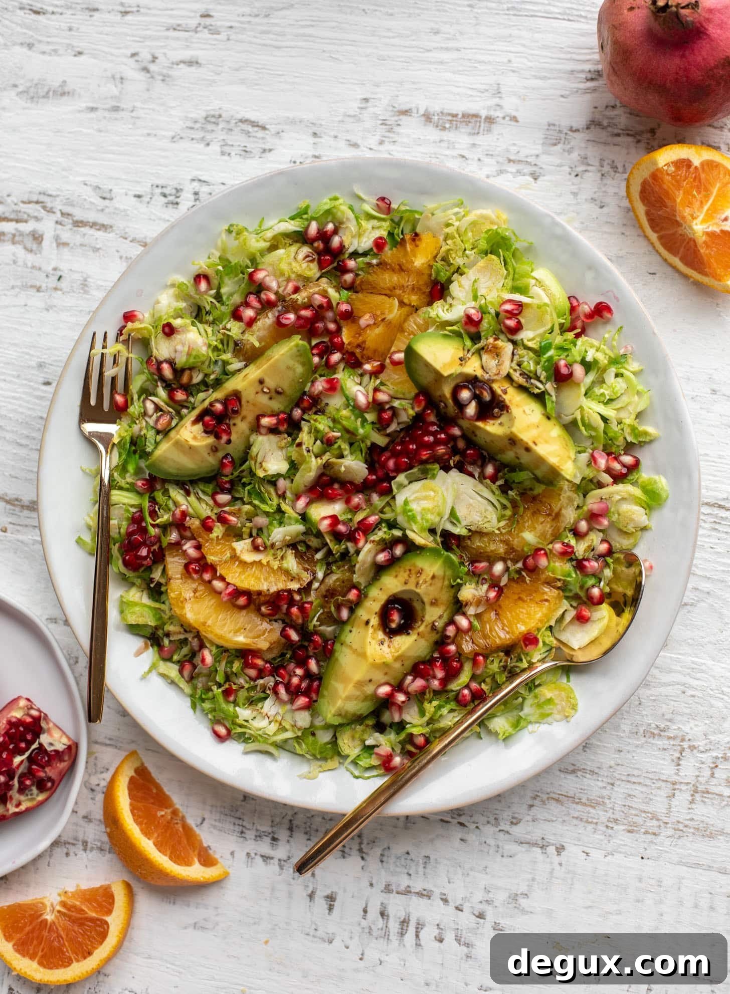 shredded citrus brussels sprouts salad with avocado and pomegranate
