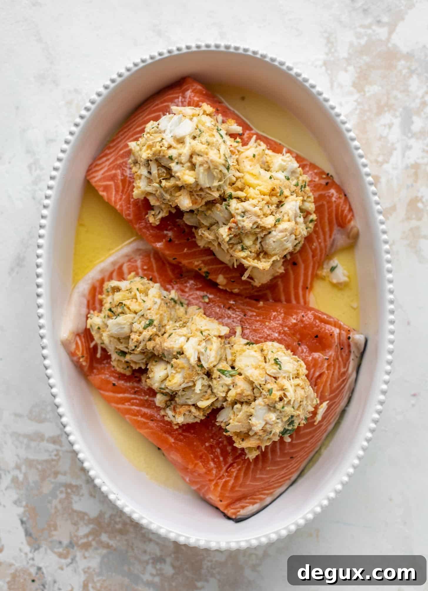salmon in a baking dish topped with crabmeat