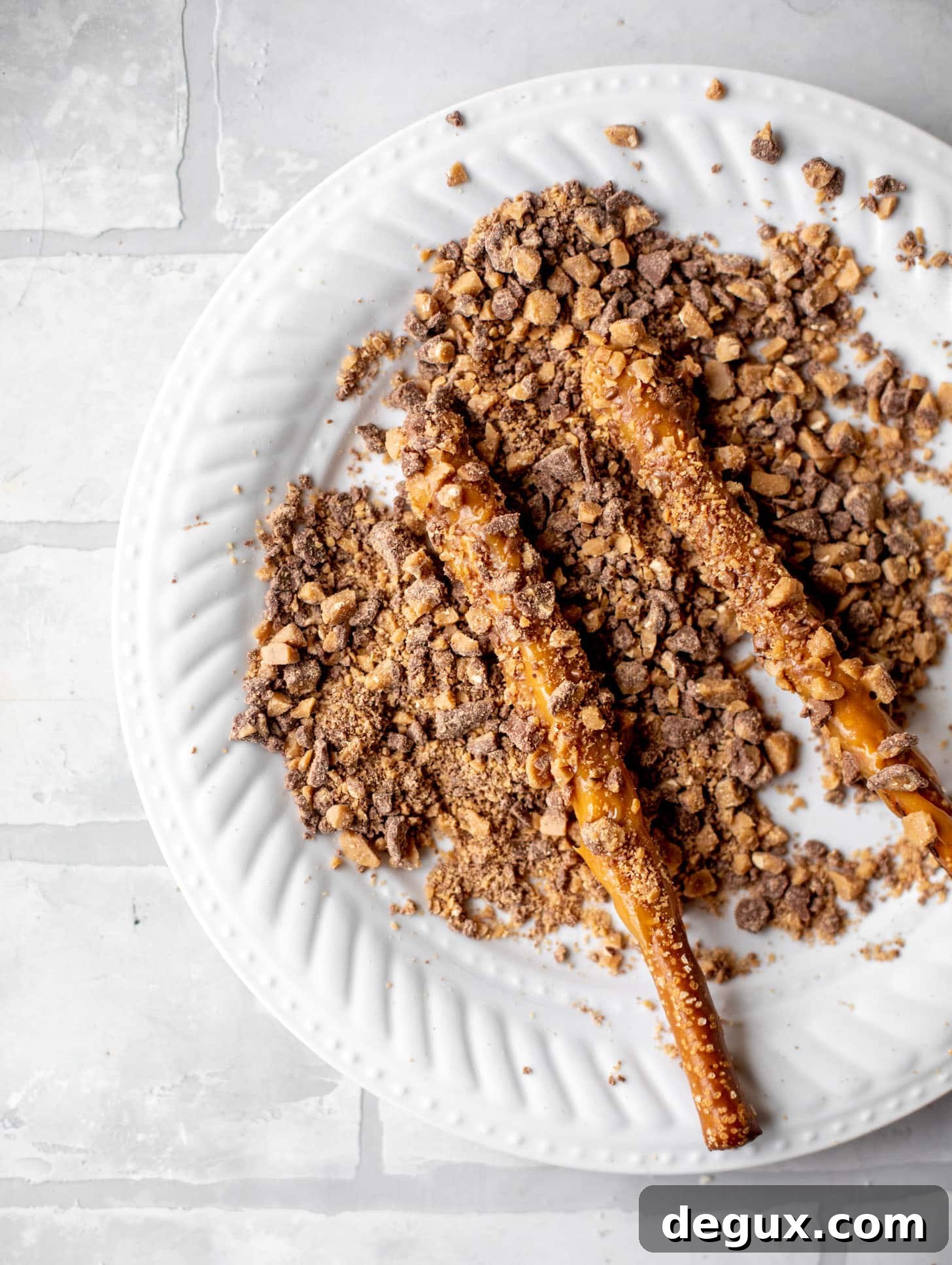 rolling caramel pretzels in toffee chips