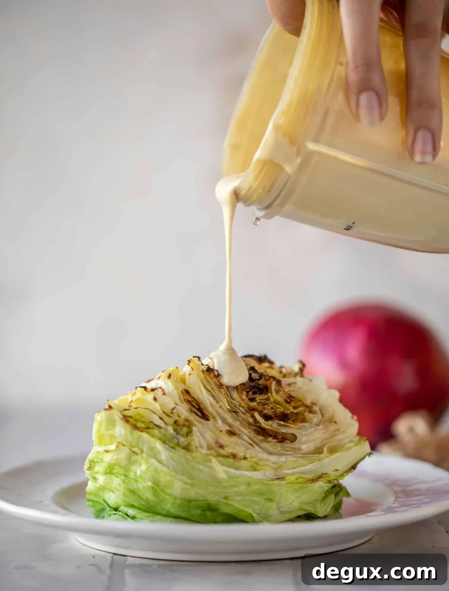 Broiled Iceberg Wedge Salad with Pomegranate Seeds & Pistachios 6 drizzling tahini ginger dressing on wedge