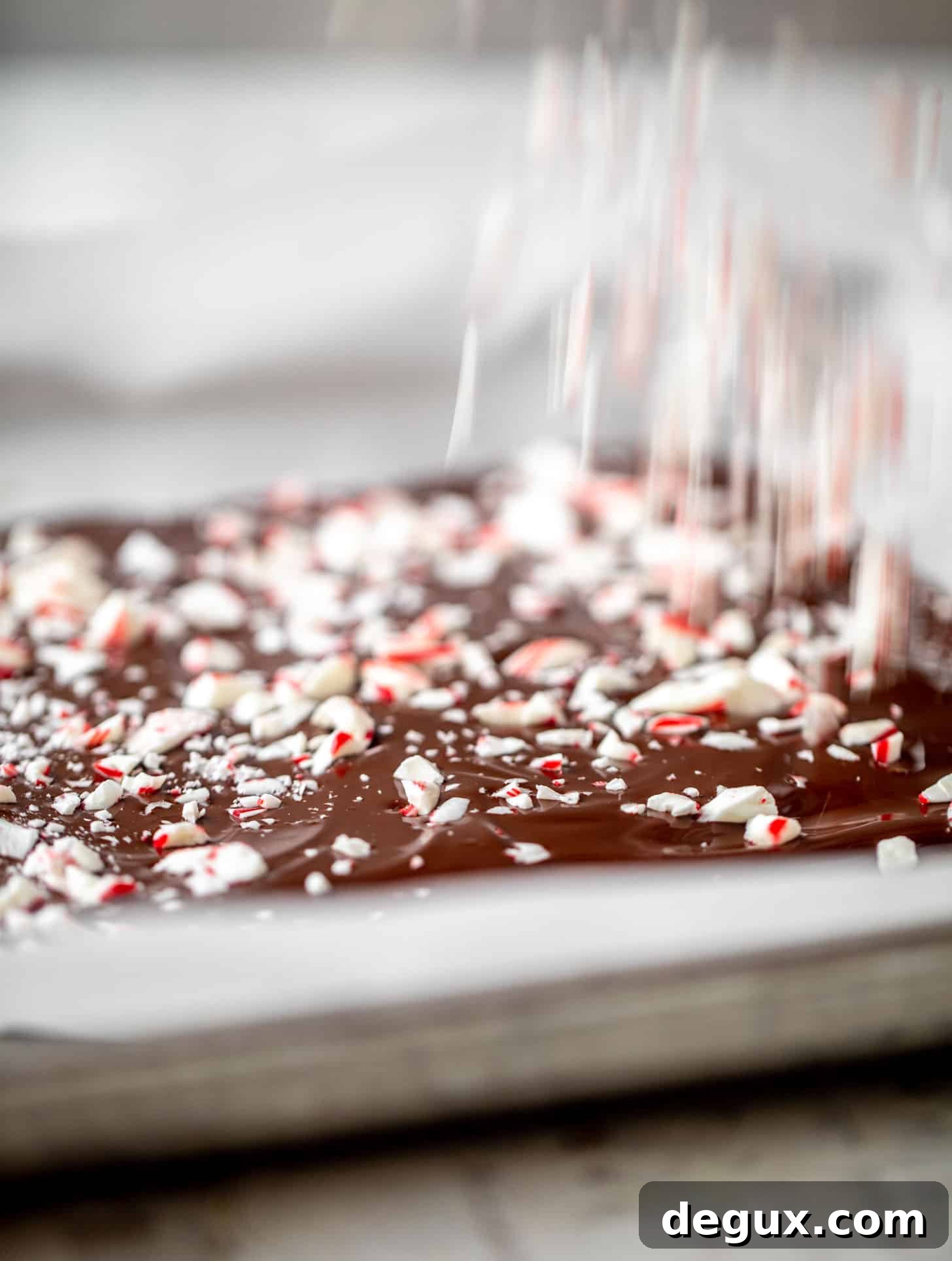 sprinkling crushed candy canes on chocolate