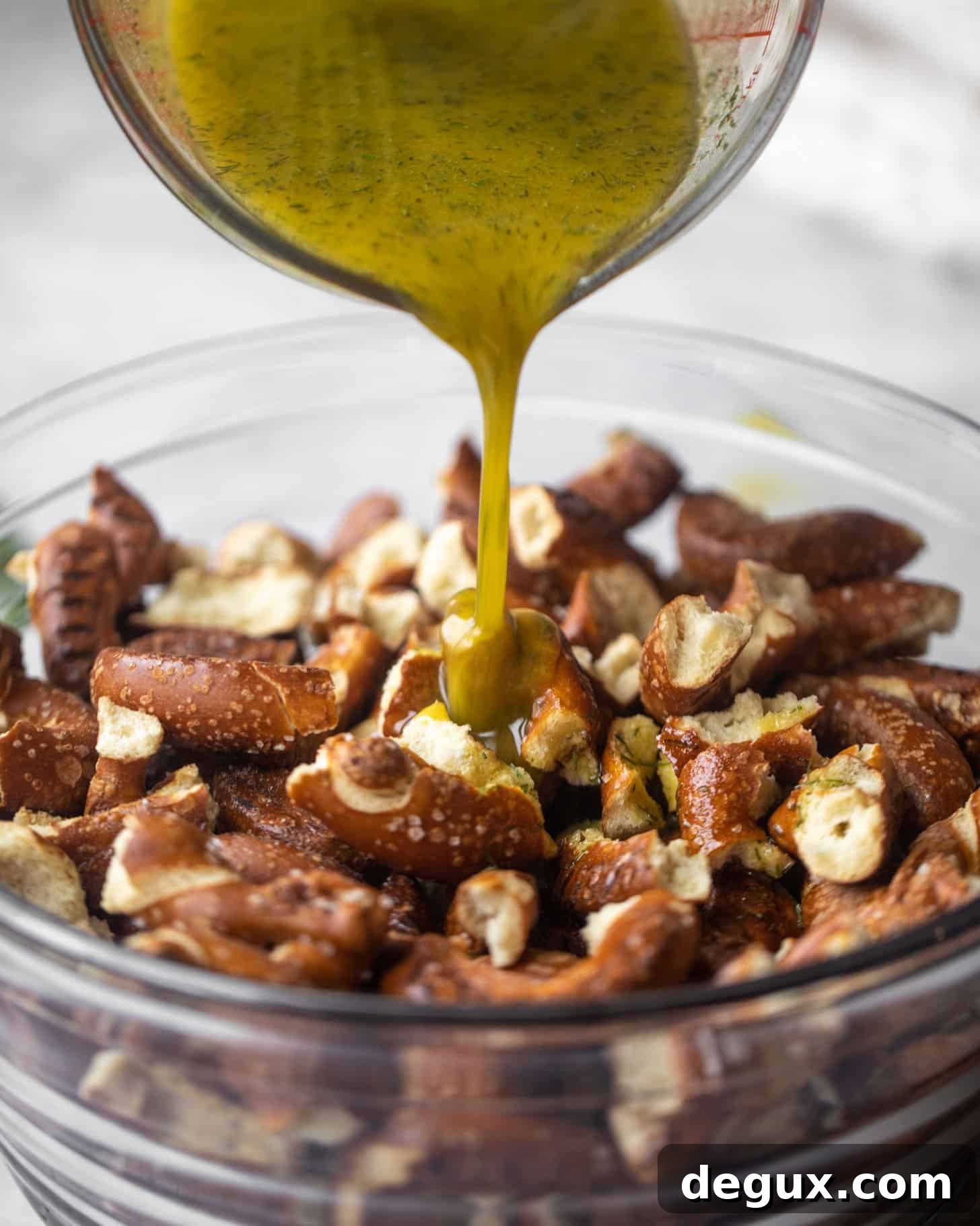 Addictive Seasoned Pretzels You Can’t Stop Eating 4 pouring seasoning on the pretzels