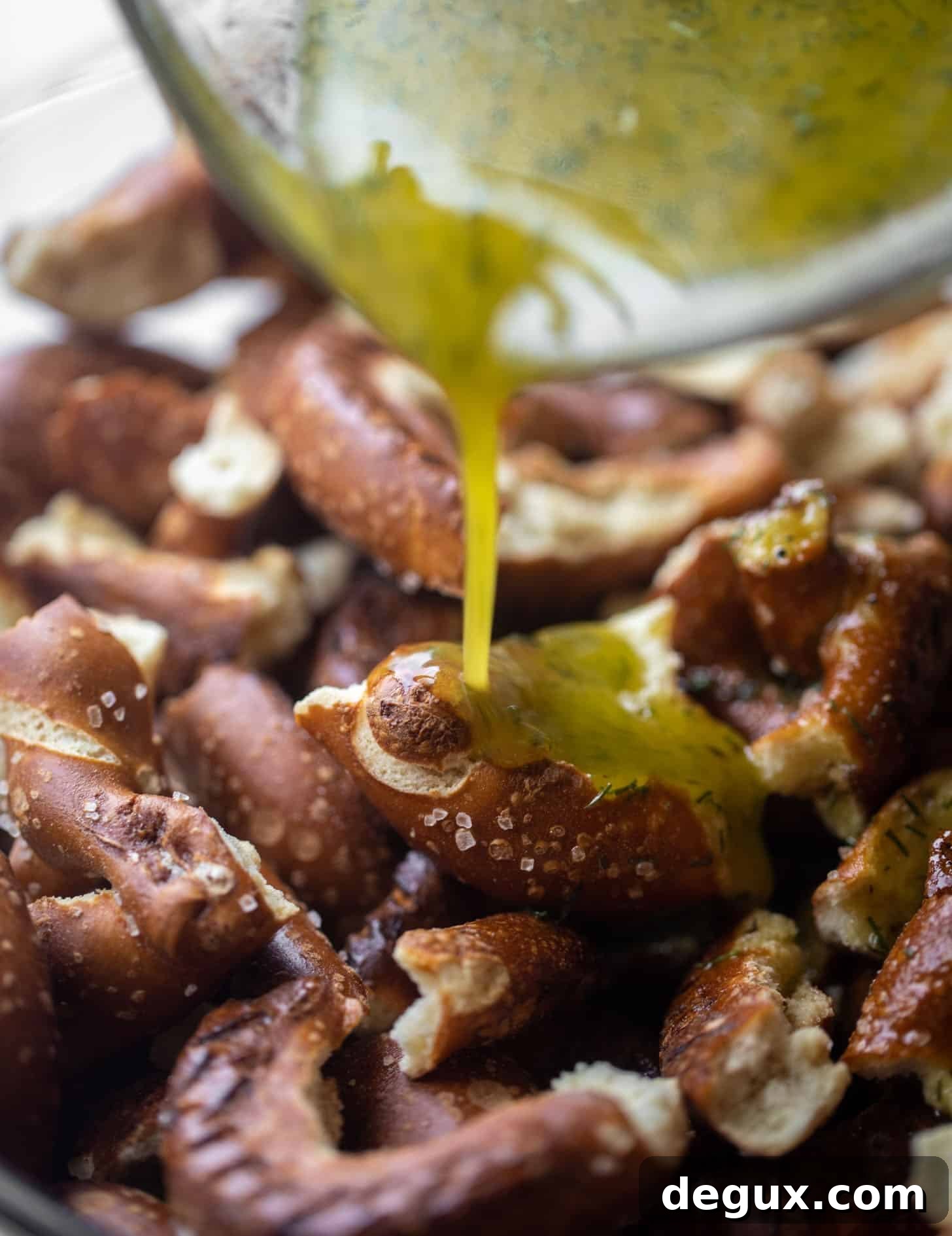 Addictive Seasoned Pretzels You Can’t Stop Eating 5 pouring seasoning on the pretzels