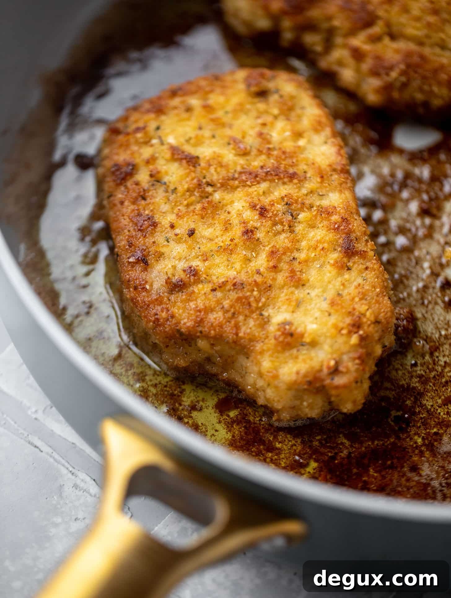 Crispy Pork Milanese with Lemon-Parmesan Arugula Salad 3 crispy pork in a skillet