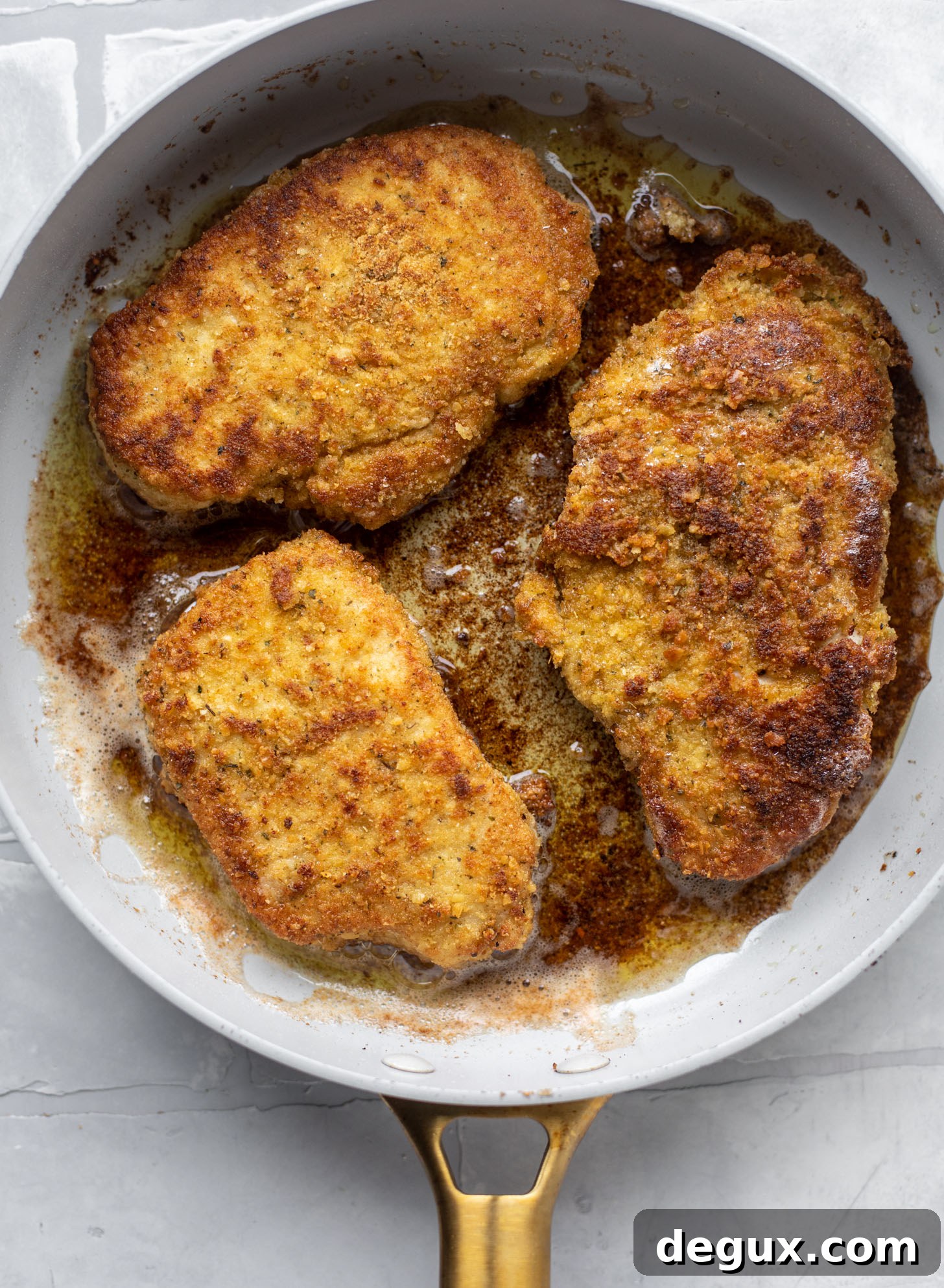 Crispy Pork Milanese with Lemon-Parmesan Arugula Salad 5 crispy pork milanese in a skillet