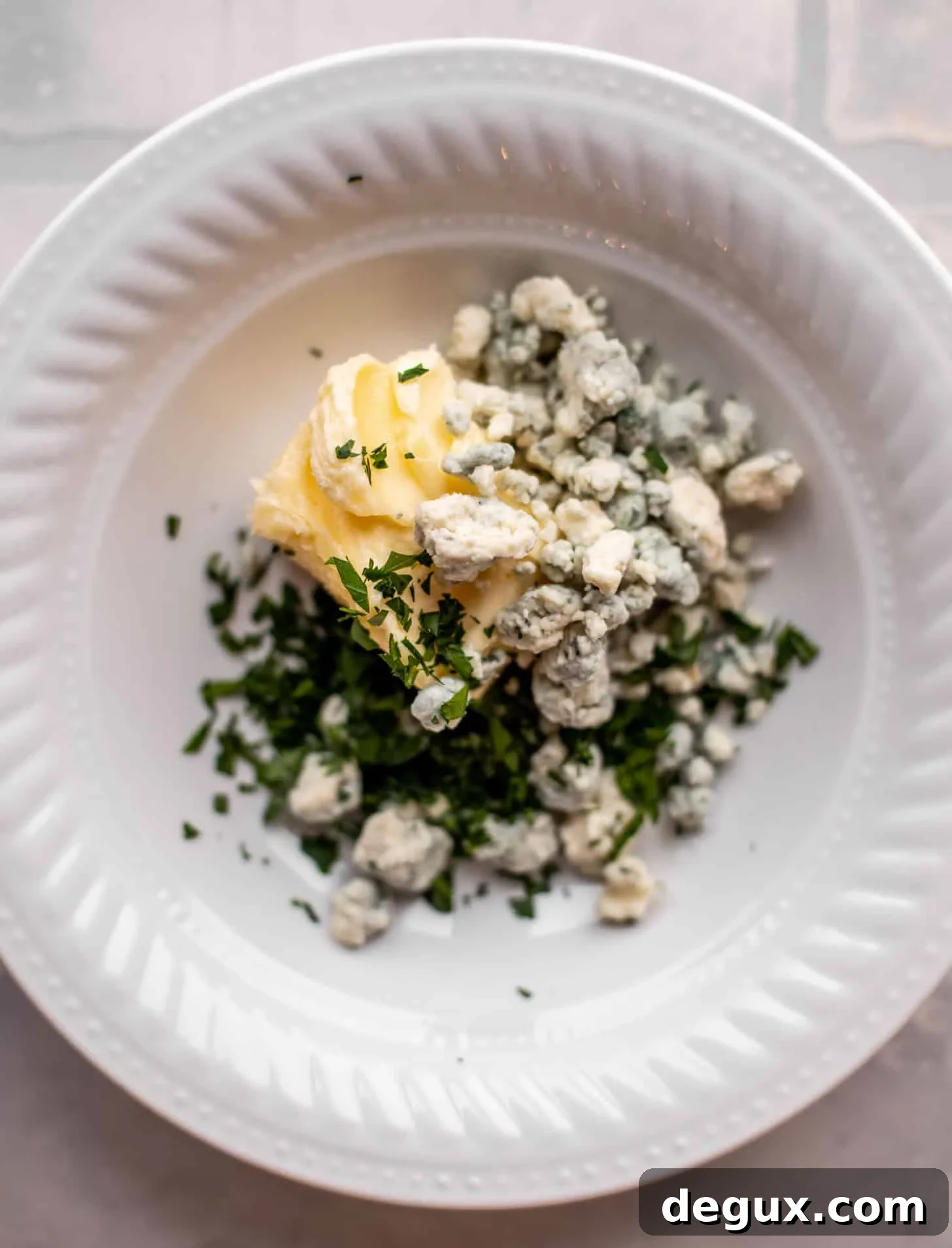 butter, herbs, blue cheese in a bowl