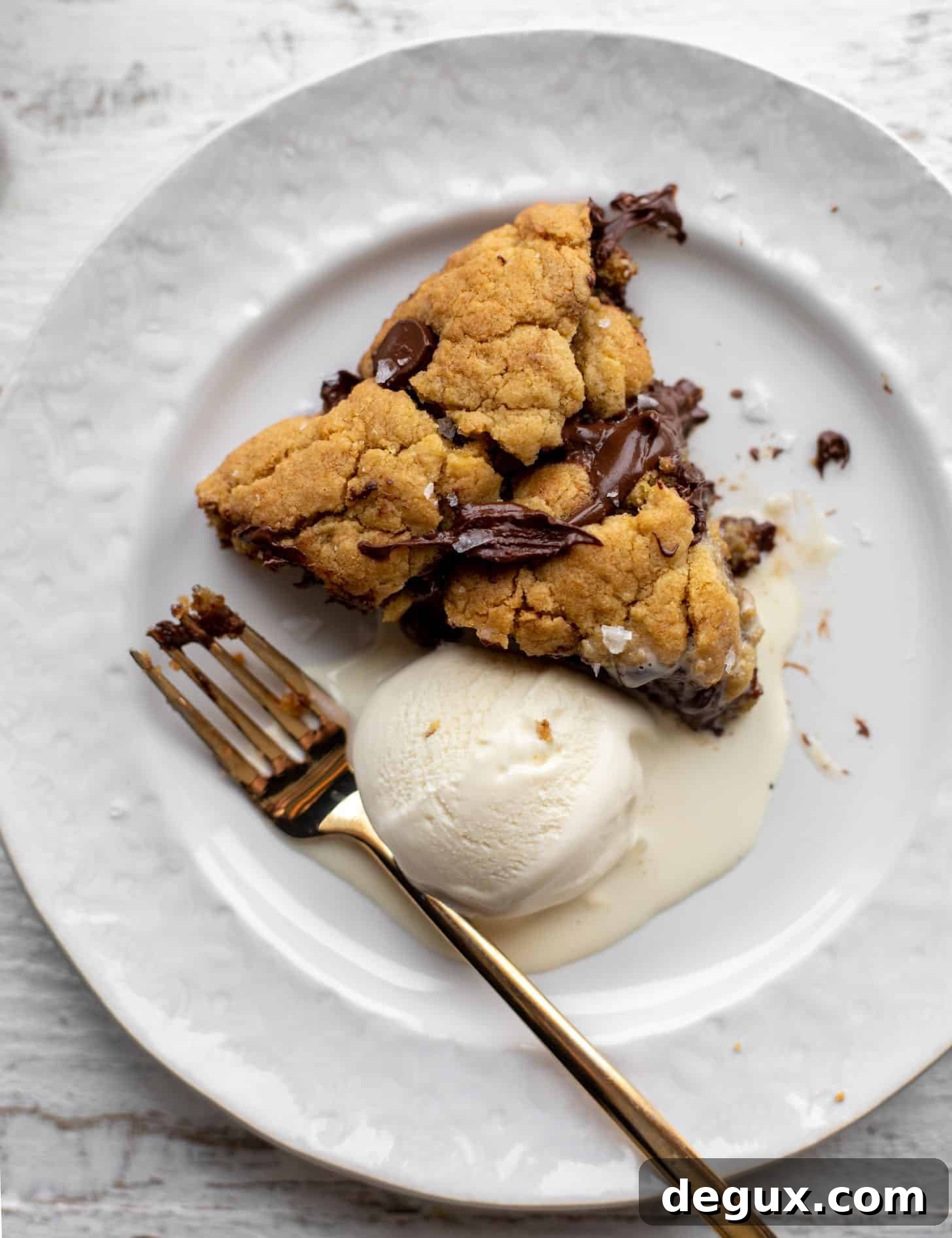 slice of chewy chocolate chip skillet cookie with ice cream