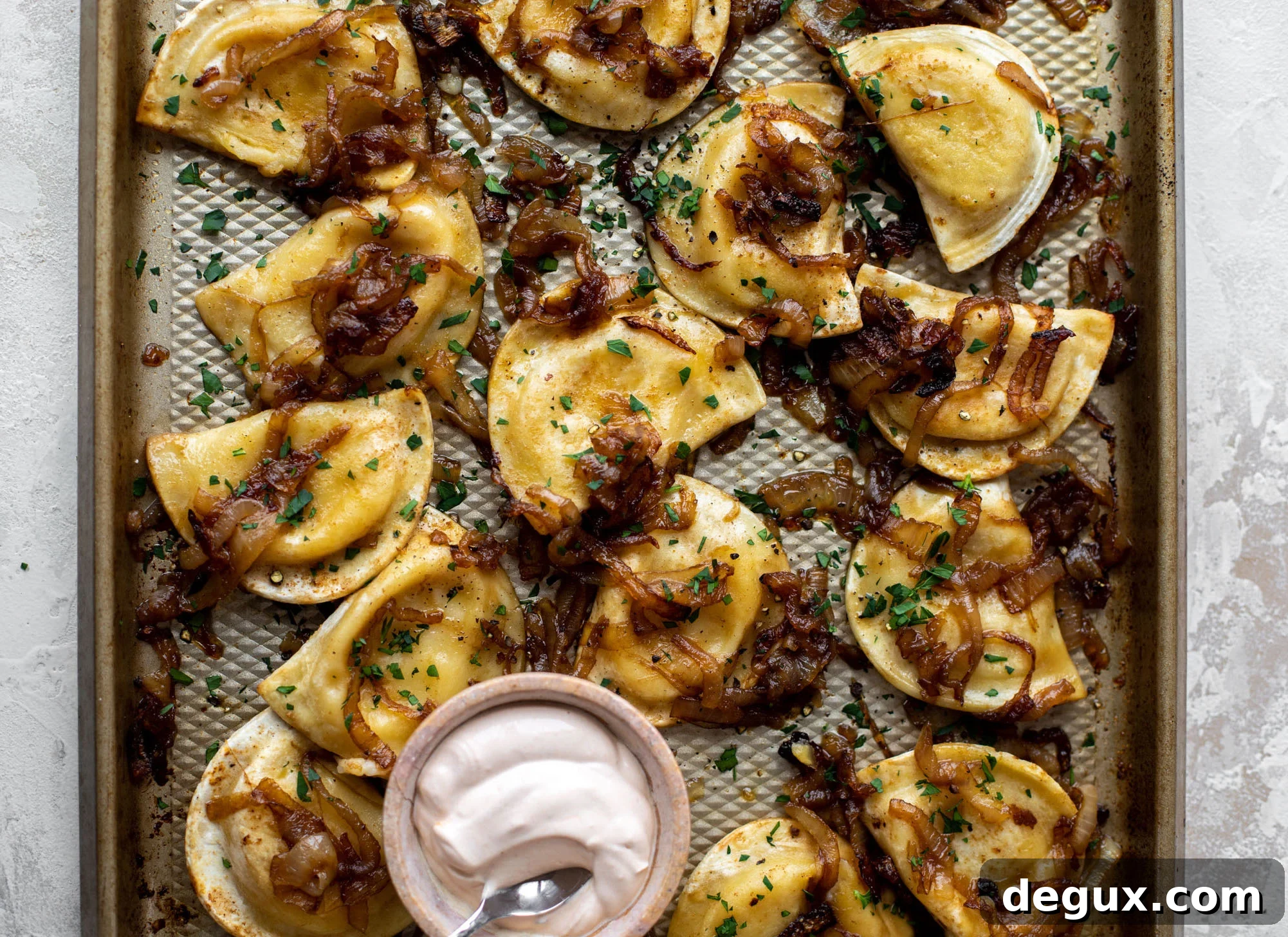 sheet pan pierogies with caramelized onions and chipotle sour cream