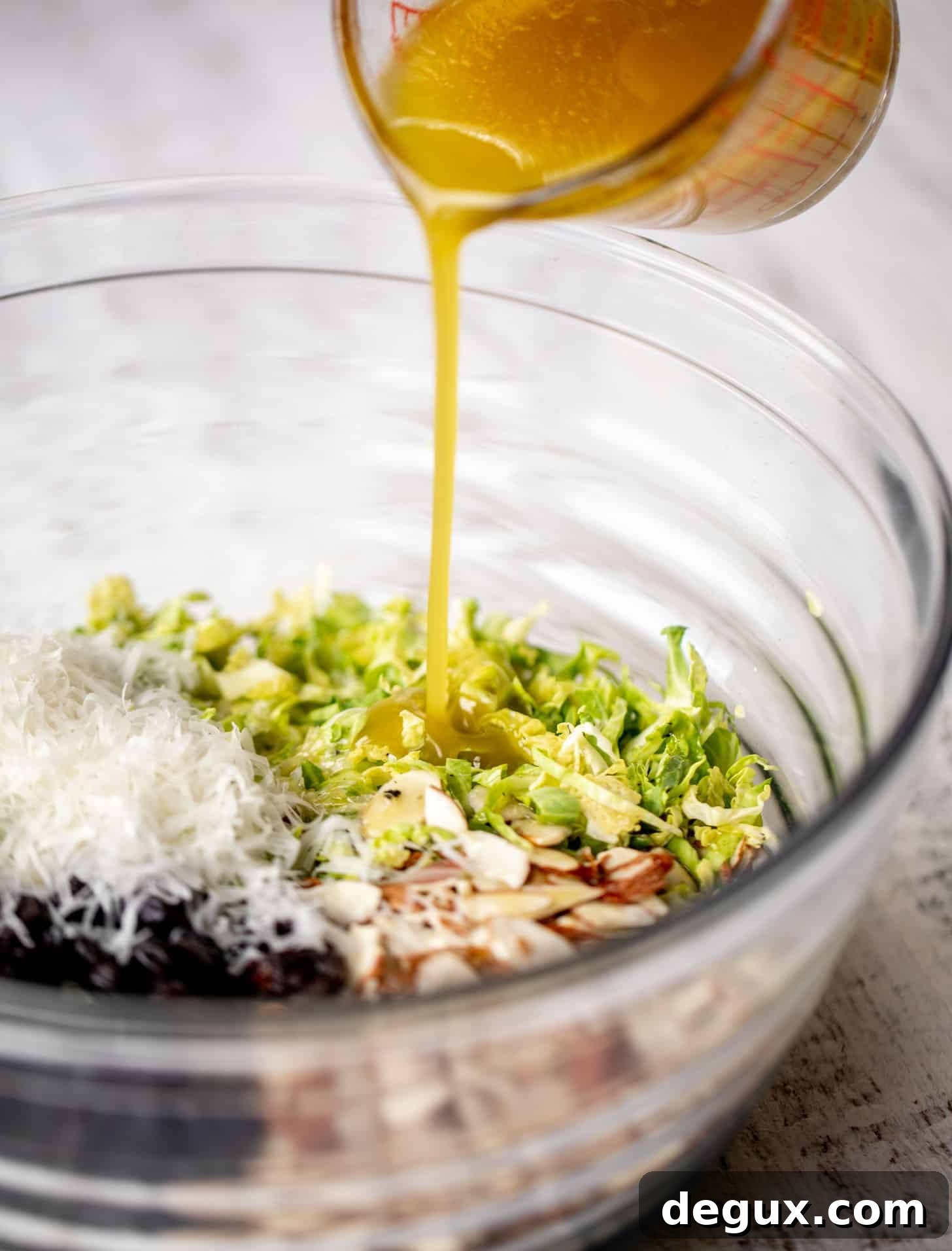 pouring dressing on brussels sprouts slaw