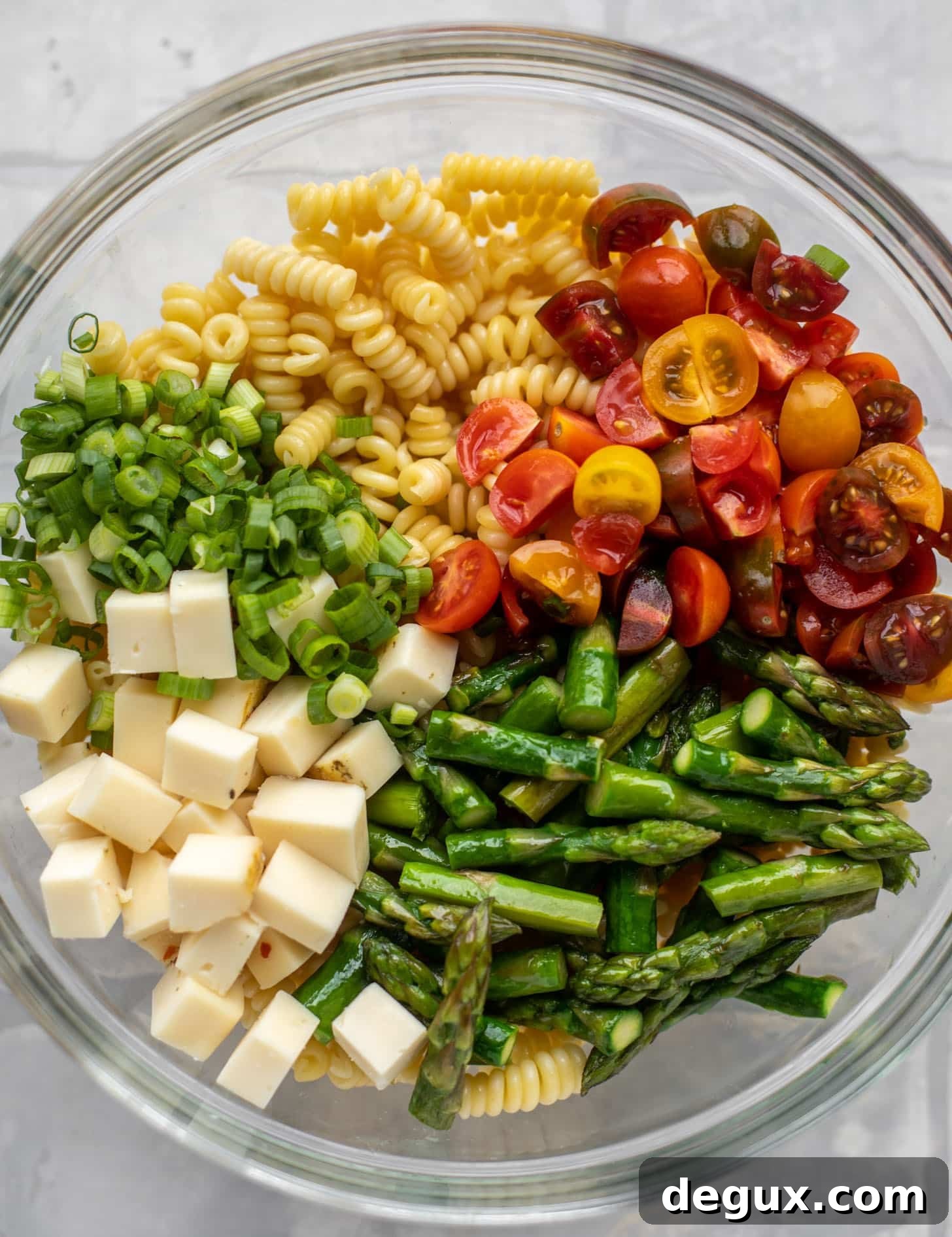 pasta, scallions, tomatoes, asparagus, cheddar in a bowl