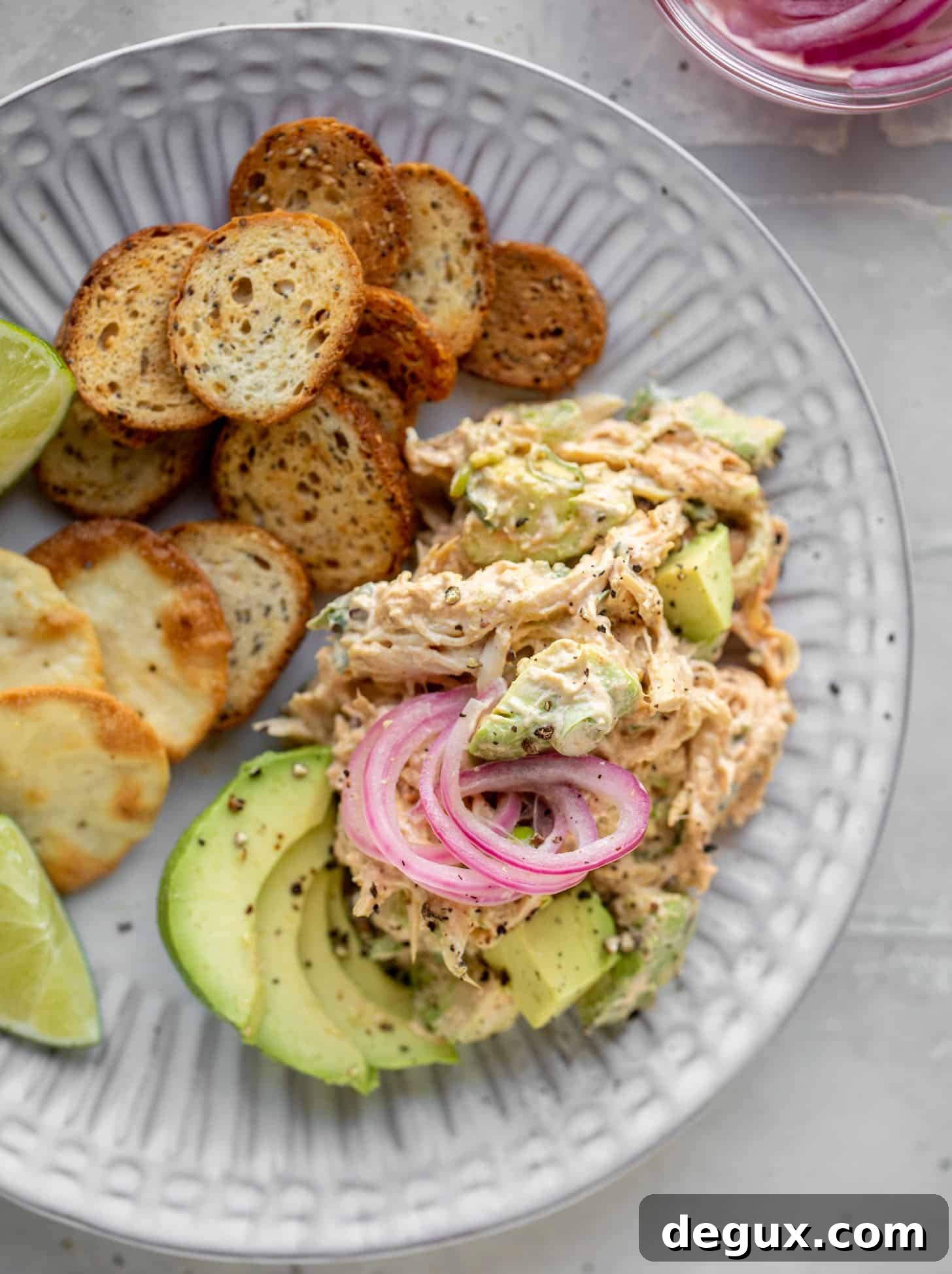 avocado chicken salad with crackers and pickled onions