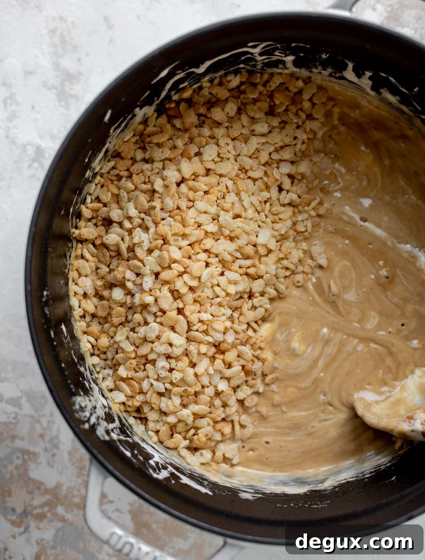Salted Peanut Butter Rice Krispie Treats Recipe — Crunchy No-Bake Bars 5 stirring the rice cereal into the peanut butter marshmallow