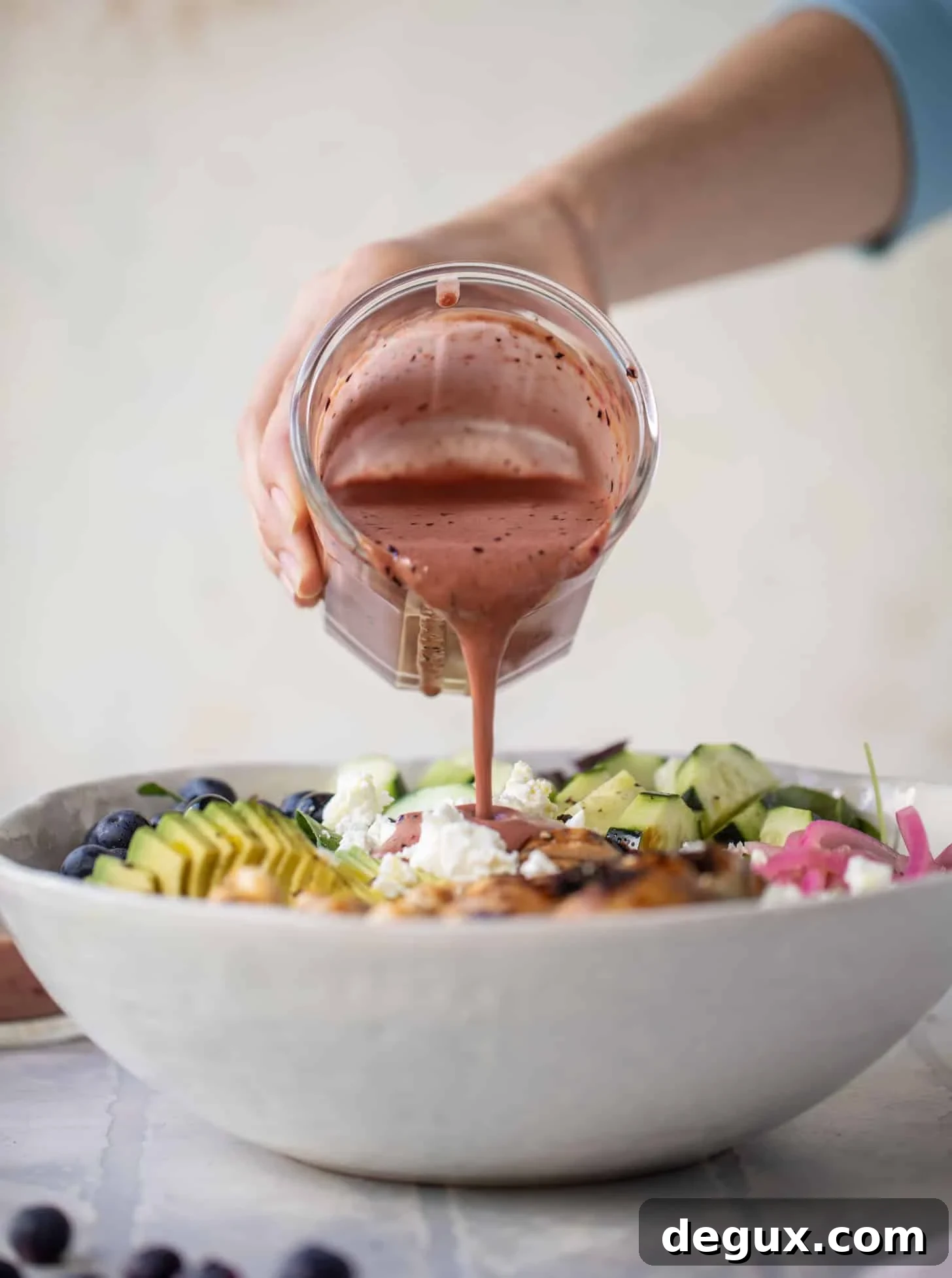 Grilled Chicken and Blueberry Salad with Herb-Sugared Marcona Almonds 6 pouring blueberry vinaigrette on salad