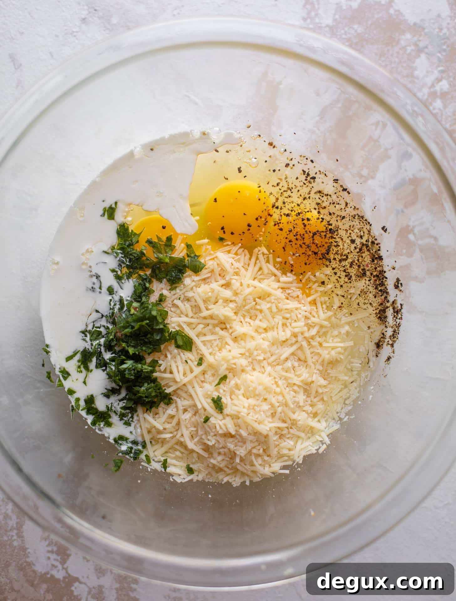 eggs, parmesan, herbs, cream in a bowl