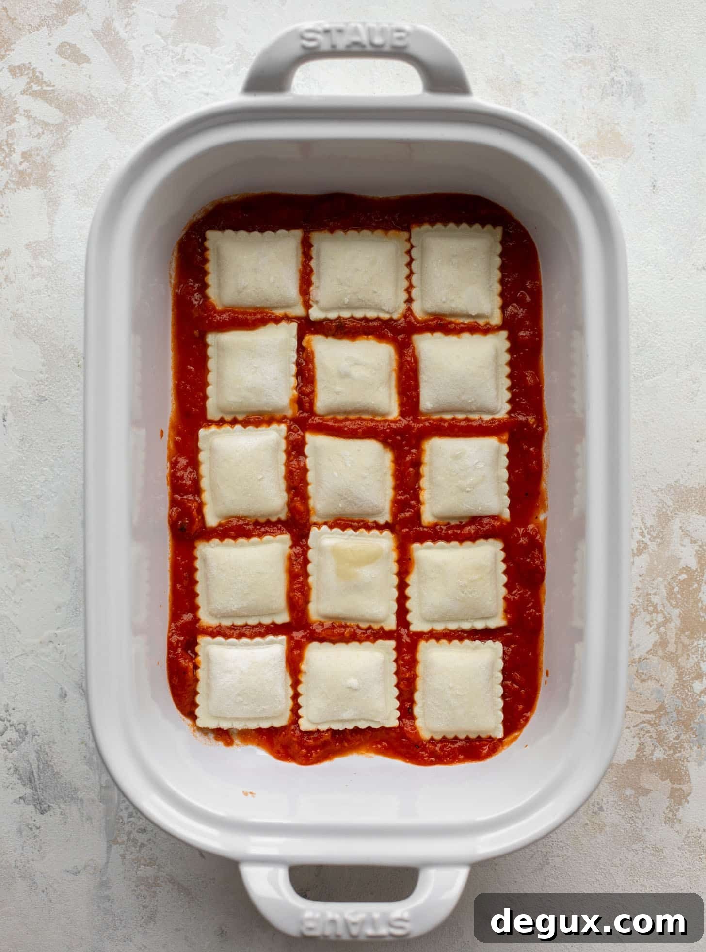 baking dish with marinara and ravioli