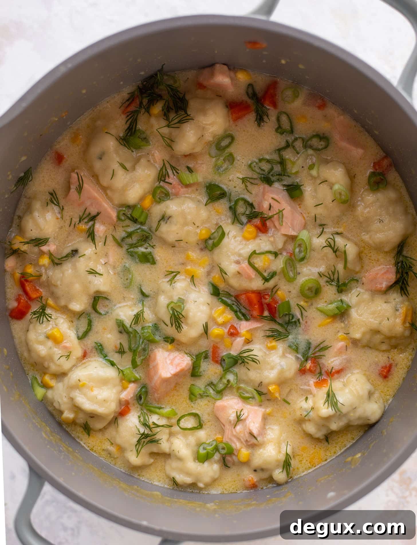 salmon chowder with dill dumplings in a pot