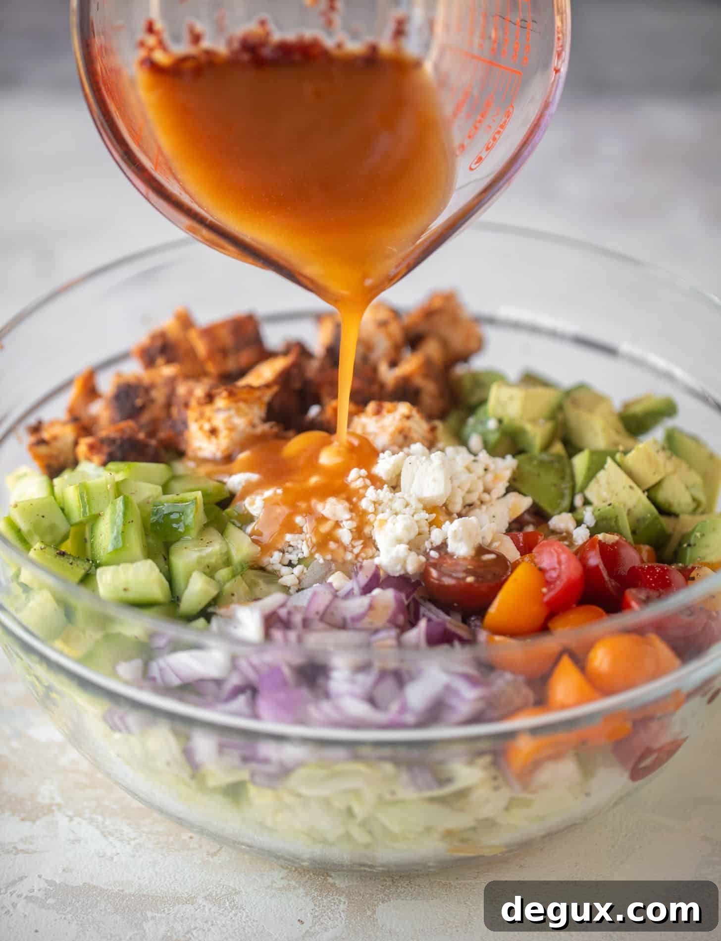 Blackened Chicken Chopped Salad with Raspberry Chipotle Vinaigrette Recipe 8 pouring dressing on blackened chicken chopped salad