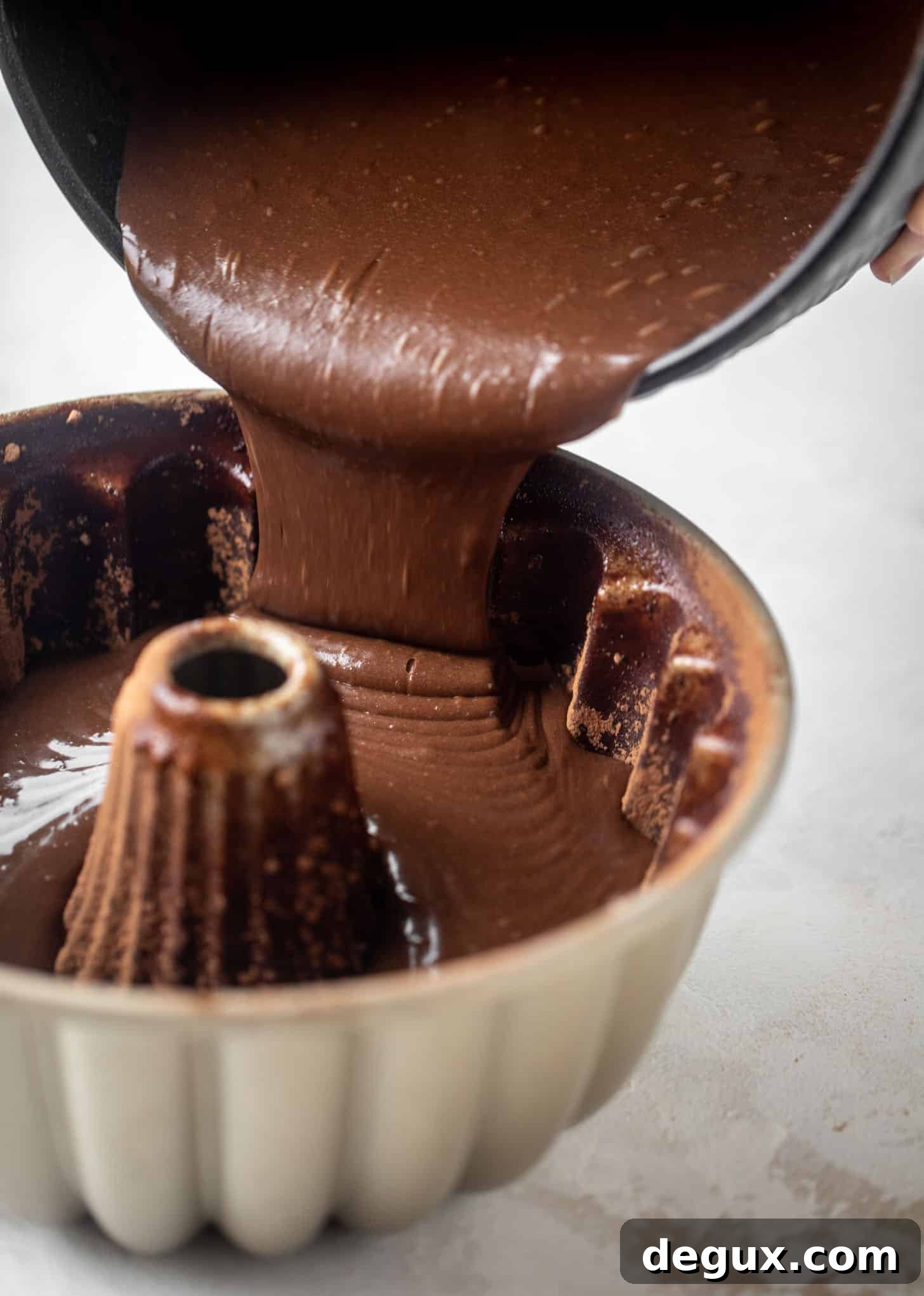 Dark Chocolate Bundt Cake with Irish Cream Glaze Recipe 4 pouring cake batter into a bundt pan