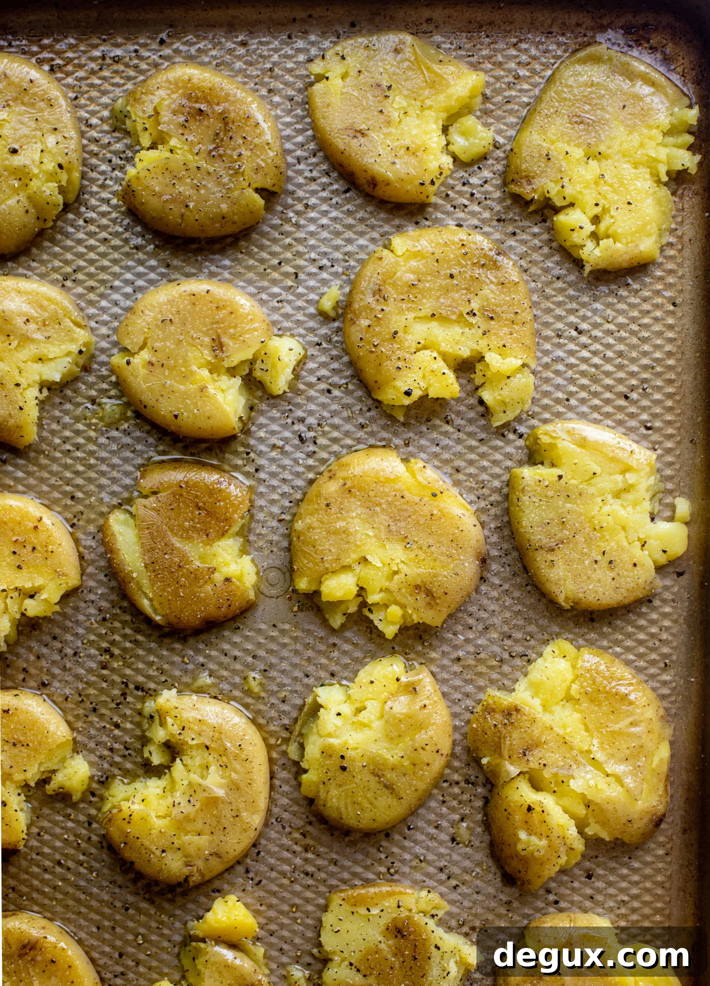 Crispy Pesto Smashed Potatoes Recipe for Crunchy Flavor 3 crispy smashed potatoes on a baking sheet