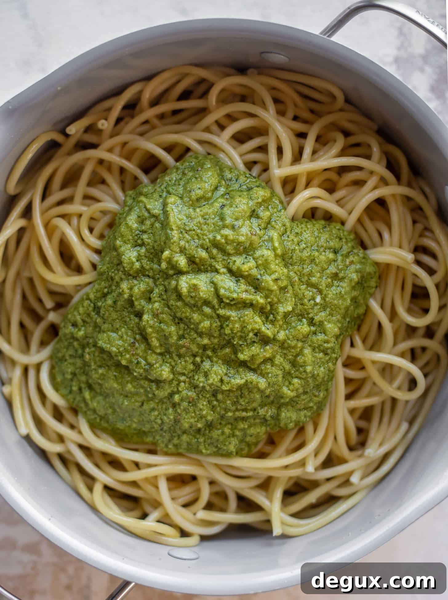 Creamy Avocado Pesto Pasta Recipe for Quick Weeknight Meals 5 bucatini topped with pesto in a pot