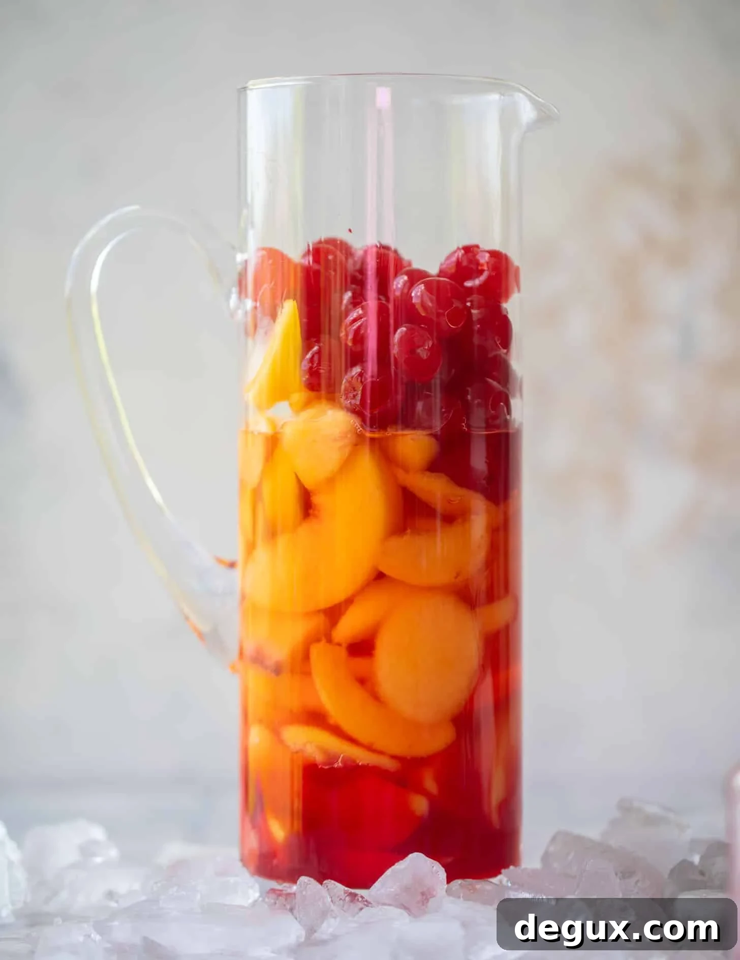 Summer Tequila Fruit Punch Recipe for Refreshing Backyard Parties 3 peaches and cherries in a pitcher