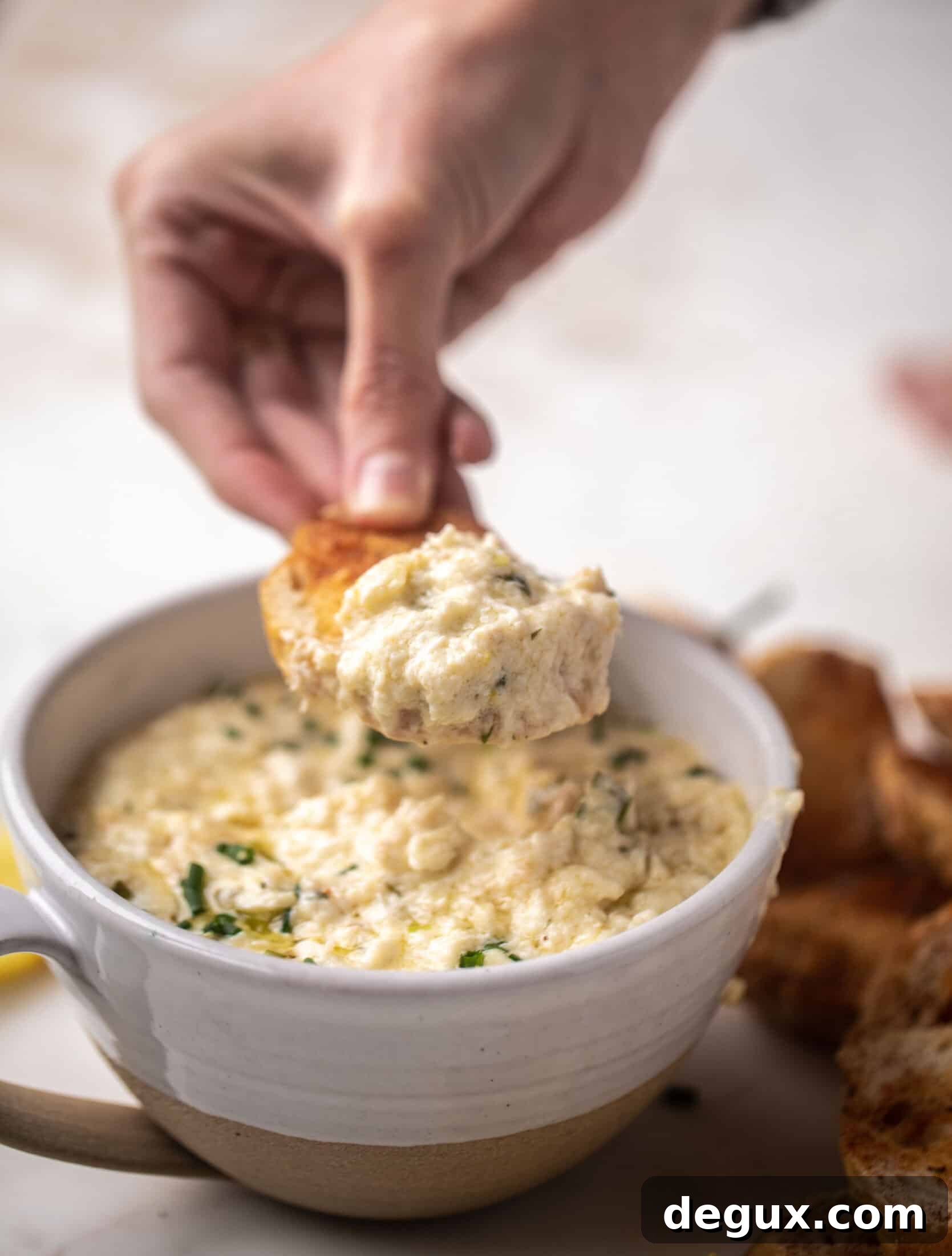 Old Bay Crab Dip with Crispy Crostini Recipe 8 dipping in the dip