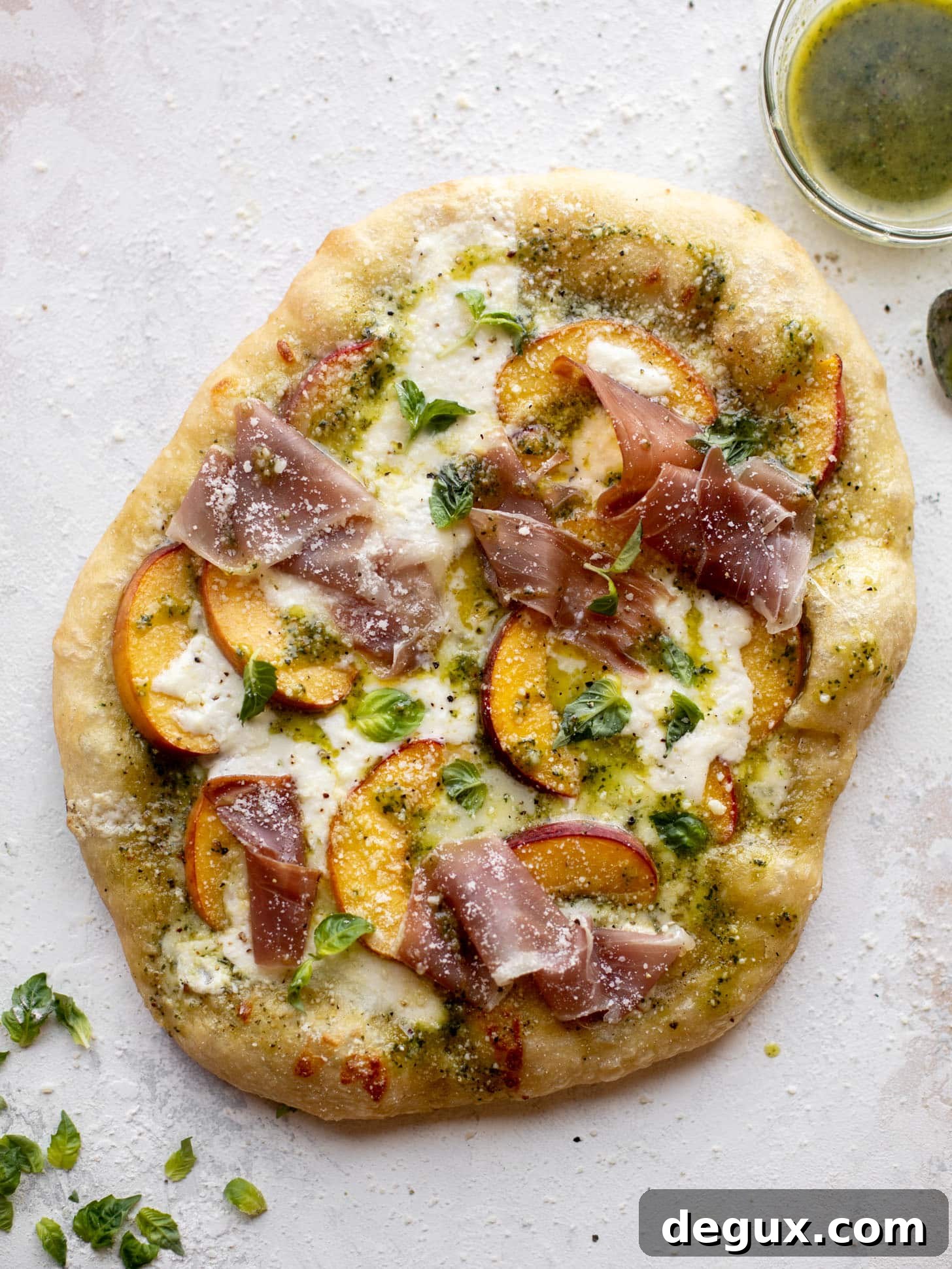 pesto peach pizza with prosciutto and burrata