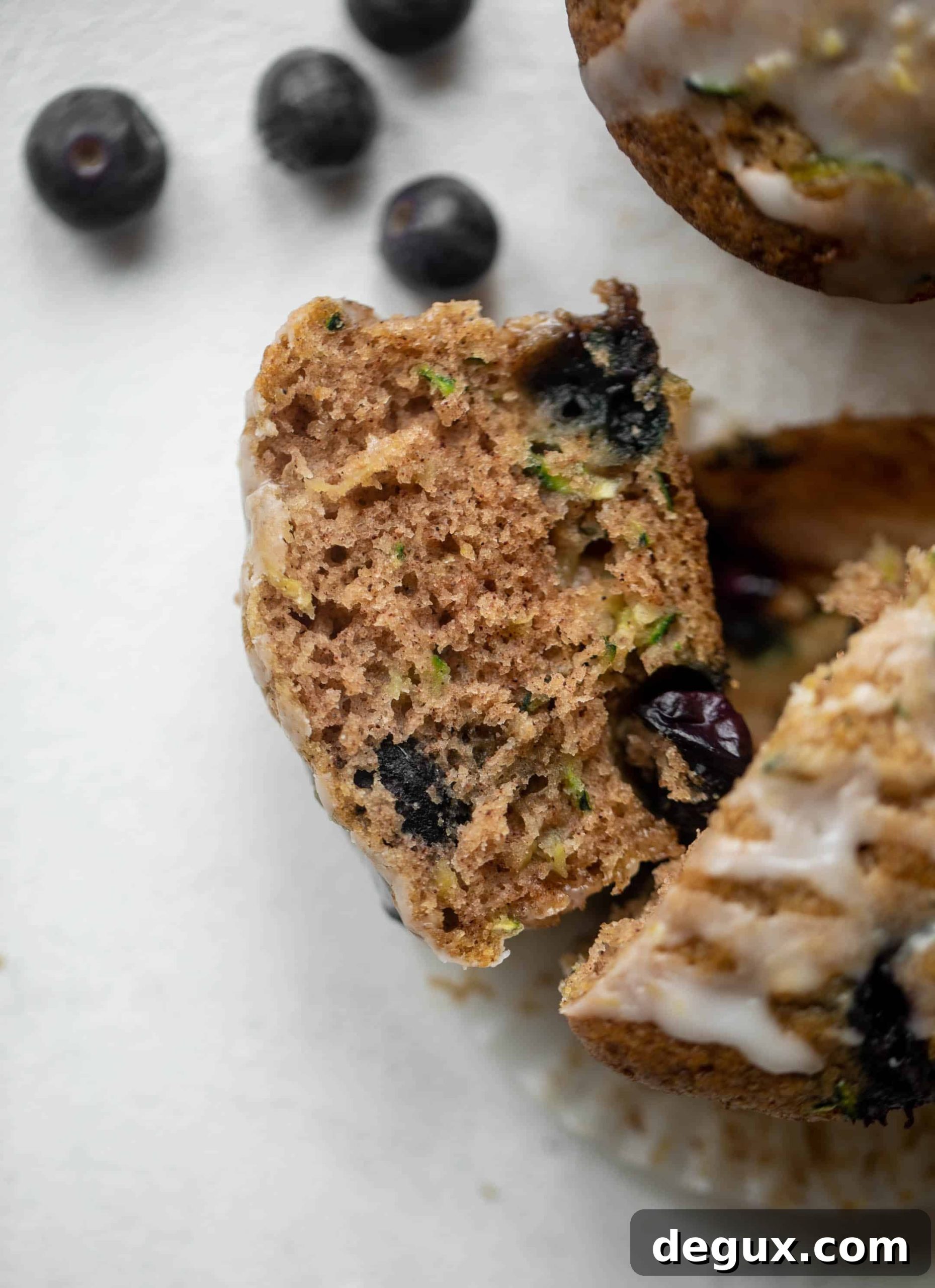 slice of blueberry zucchini muffins with lemon glaze