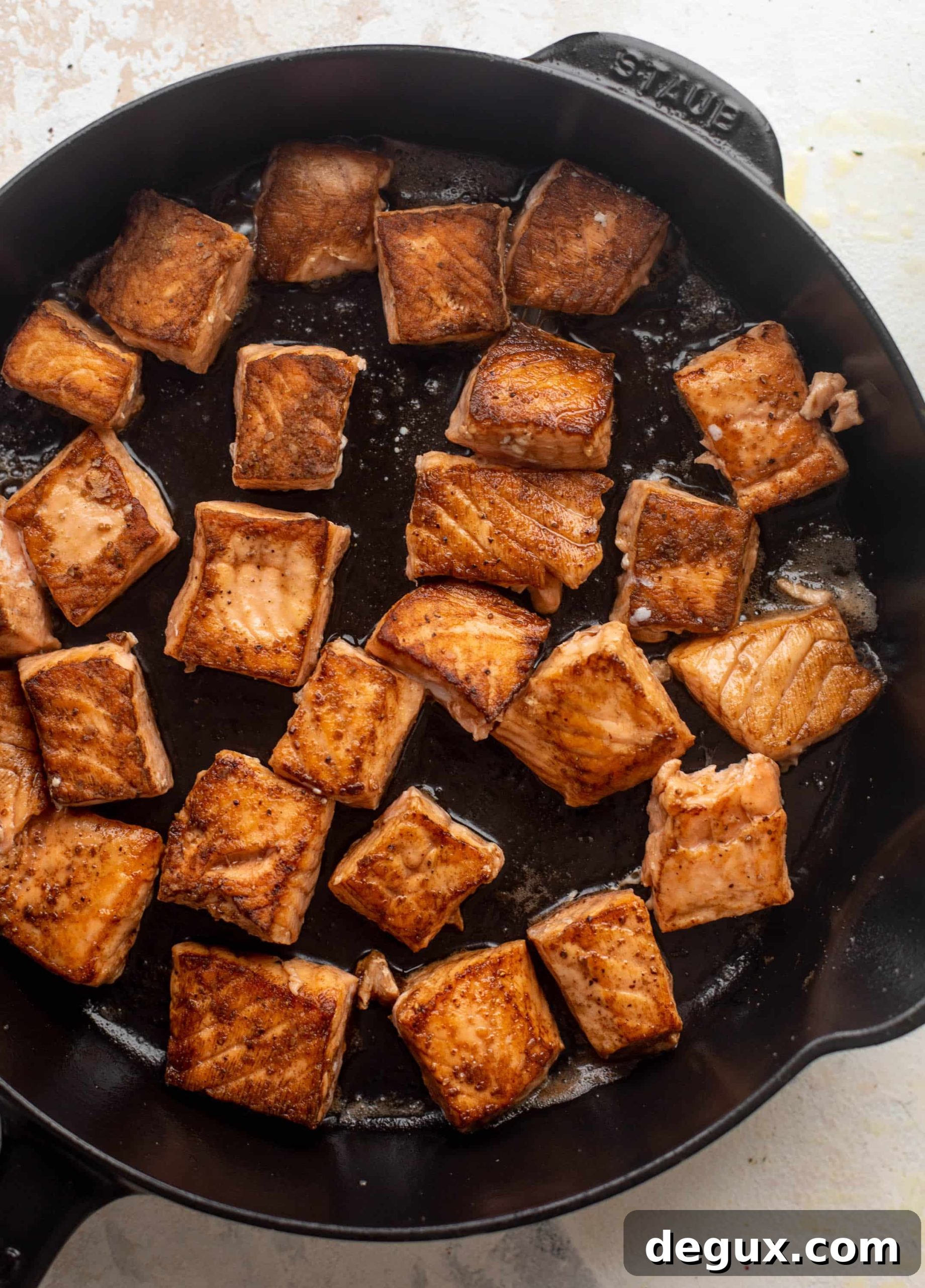 Sticky Salmon Couscous Bowls with Tangy Soy Glaze 4 seared salmon in a cast iron skillet